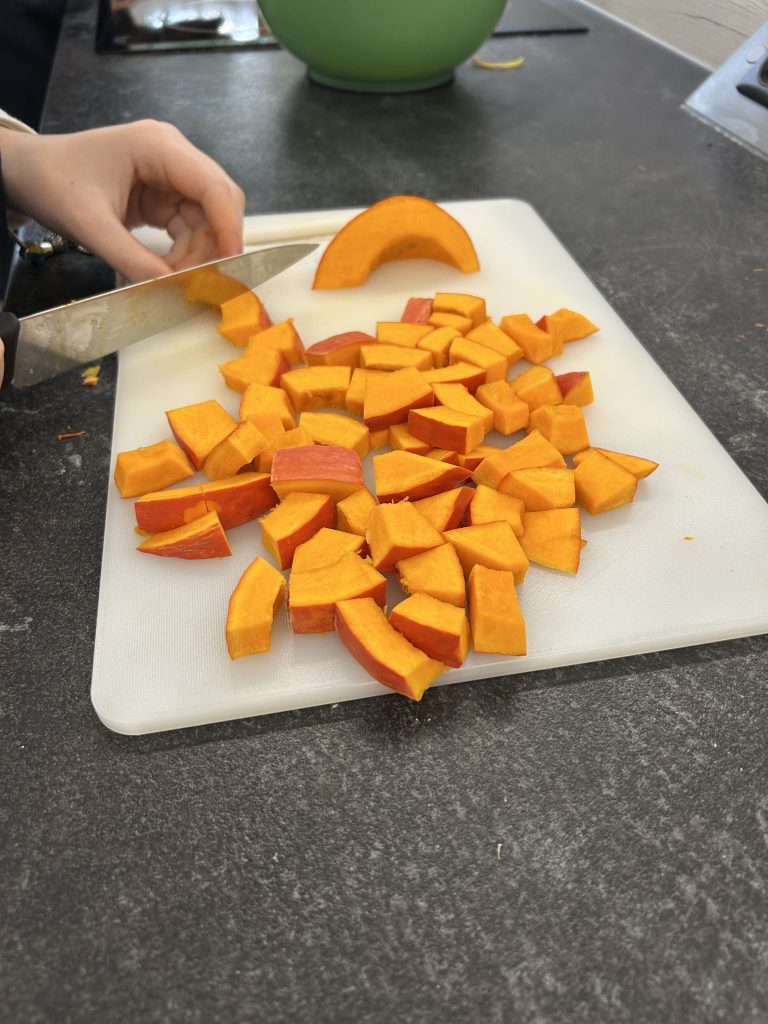 Kürbissstücke, die mit einem Messer geschnitten werden